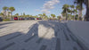 A fast-paced, cheerful video compilation tracking a young child as they explore diverse landscapes on a vibrant Cruzee balance bike. The video cuts between different scenic locations—zipping down smooth suburban sidewalks, navigating leafy park pathways, coasting through a bustling urban plaza, and rolling across a sunny, open grassy field. The child wears a safety helmet and has a joyful expression, confidently gliding and steering the lightweight bike through every new environment.
